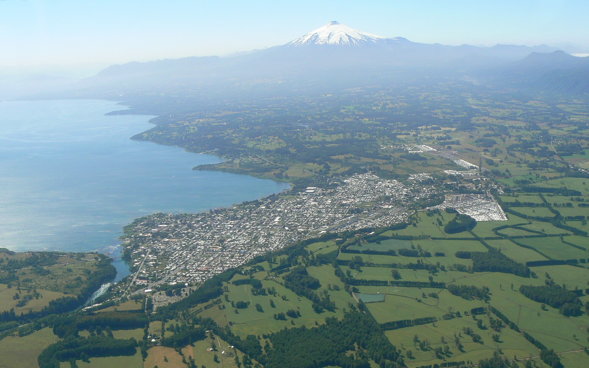 Vista aérea de Villarrica, su lago, campos y volcán en La Araucanía, Chile